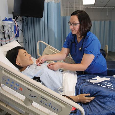 Immaculata University Adult and Professional Degrees nursing student working with a mannequin